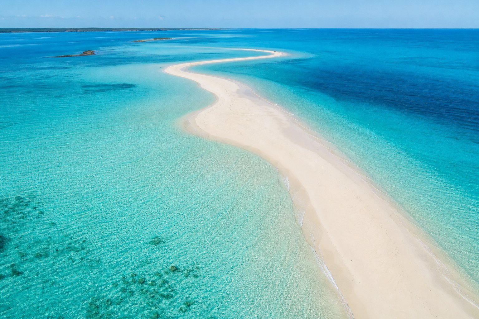 Aerial view of a sandbar surrounded by clear turquoise water