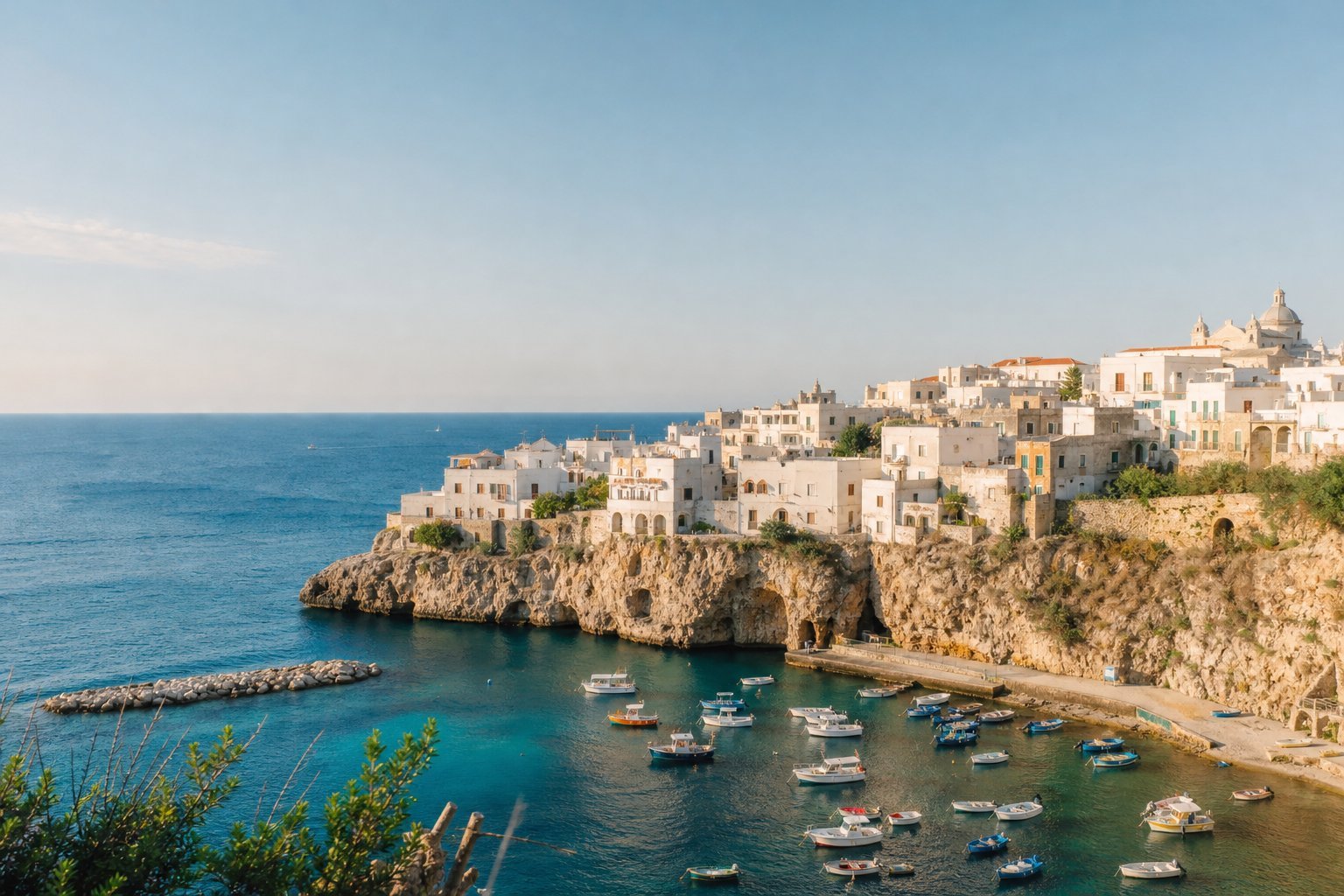 Whitewashed coastal buildings above a deep blue Mediterranean bay